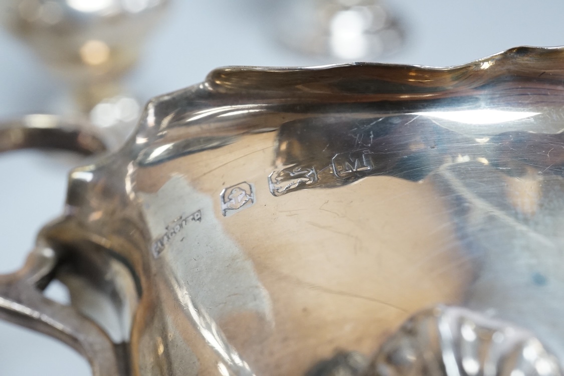 Two George V silver sauceboats, one by Asprey & Co, a silver pepperette, a silver bowl and a modern silver sugar caster, 16oz.